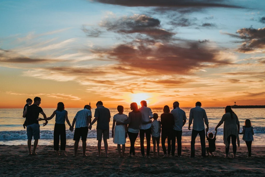 Familie van meerdere generaties hand in hand bij zonsondergang