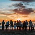 Familie van meerdere generaties hand in hand bij zonsondergang