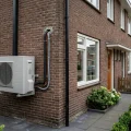 buitenunit van een hybride warmtepomp tegen de gevel van een Nederlandse woning